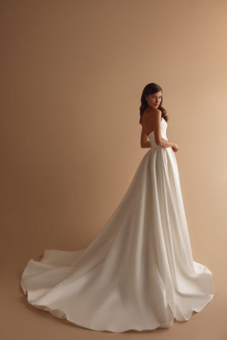 Brautkleid Gianna von hinten: Das schlichte Satin-Design wird durch den cleanen, weit fallenden Rock mit eleganter Schleppe ergänzt. Die minimalistische Eleganz des Kleides steht im Fokus
