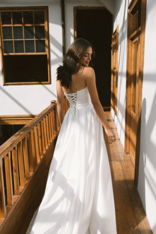 Brautkleid Vilda von hinten: Schmale, cleane A-Linie mit eleganter Schnürung im Rücken. Diese sorgt für einen perfekt anliegenden Sitz und verleiht dem Kleid eine einzigartige, romantische Note