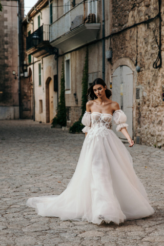 Nahaufnahme des Brautkleids Aster: Zarte 3D-Spitzenstickerei auf der Vorderseite und abnehmbare Puffärmel, die dem Kleid eine romantische, verspielte Note verleihen