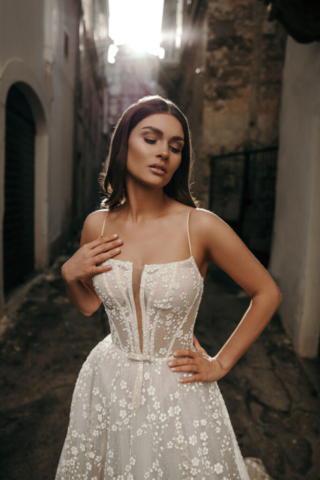 Nahaufnahme des Brautkleids Irma: Transparenter, glitzernder Tüll mit filigraner Blumenstickerei, schmaler V-Ausschnitt und feine Träger