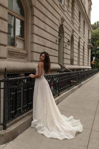 Detail des Brautkleids Bria: 3D-Blumenstickerei an der Taille, die wie ein Gürtel wirkt. Glitzernder Tüll mit weißen Punkten und seitliche Taschen für zusätzlichen Komfort.