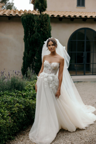 Detail des Brautkleids Carlotta: Glitzernde Korsage mit vereinzelten 3D-Applikationen und einem Ausschnitt, der an den Seiten spitz nach oben verläuft. Diese besonderen Details sorgen für einen raffinierten Effekt.