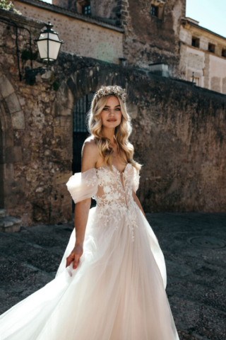 Brautkleid Leyla seitlich: A-Linie aus Tüll mit tiefem Beinschlitz für einen modernen Look. Die spitz zulaufende Korsage und zarten Blumenapplikationen unterstreichen die Eleganz des Kleides.